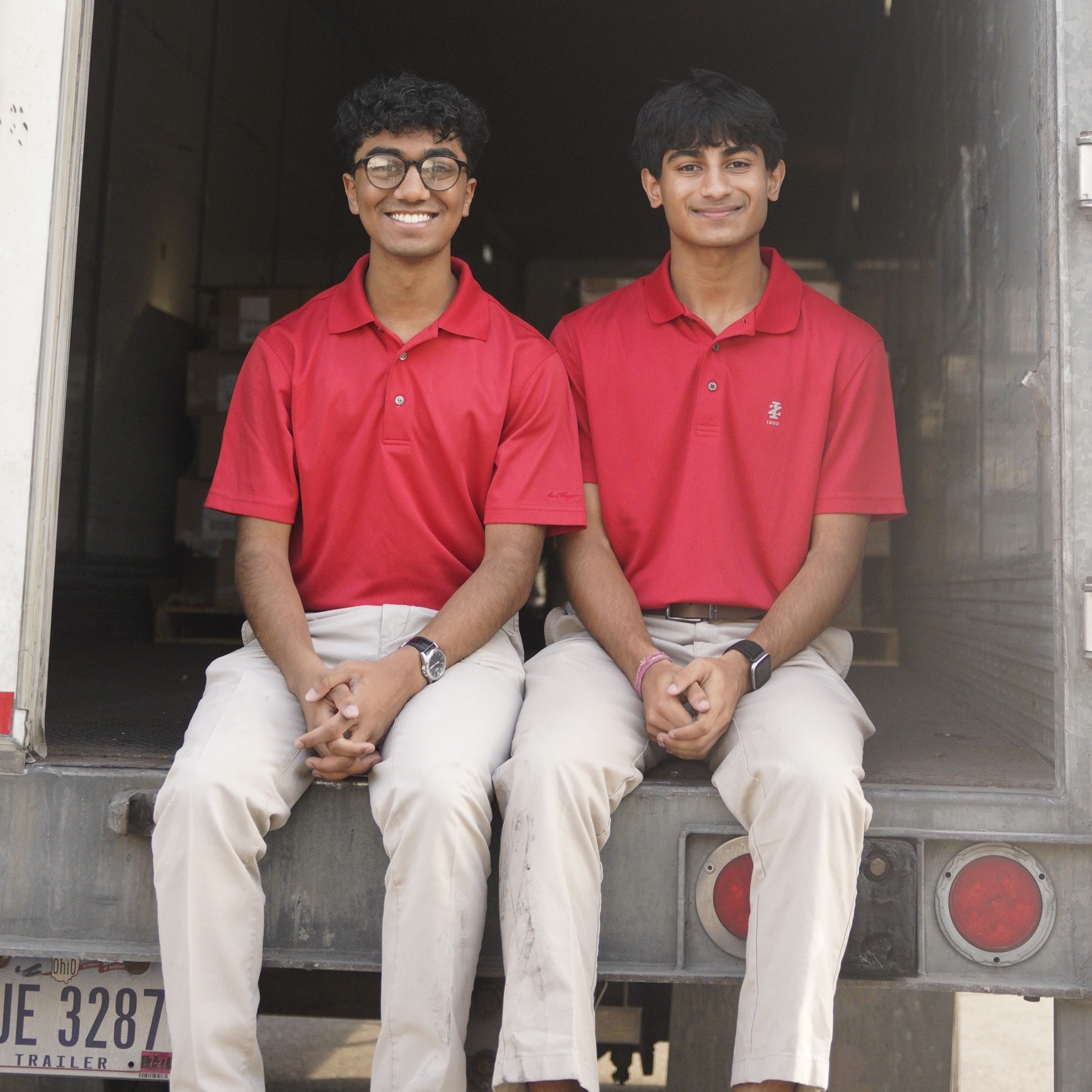Ben Kurian and Naman Soni sitting on the back of the loaded truck